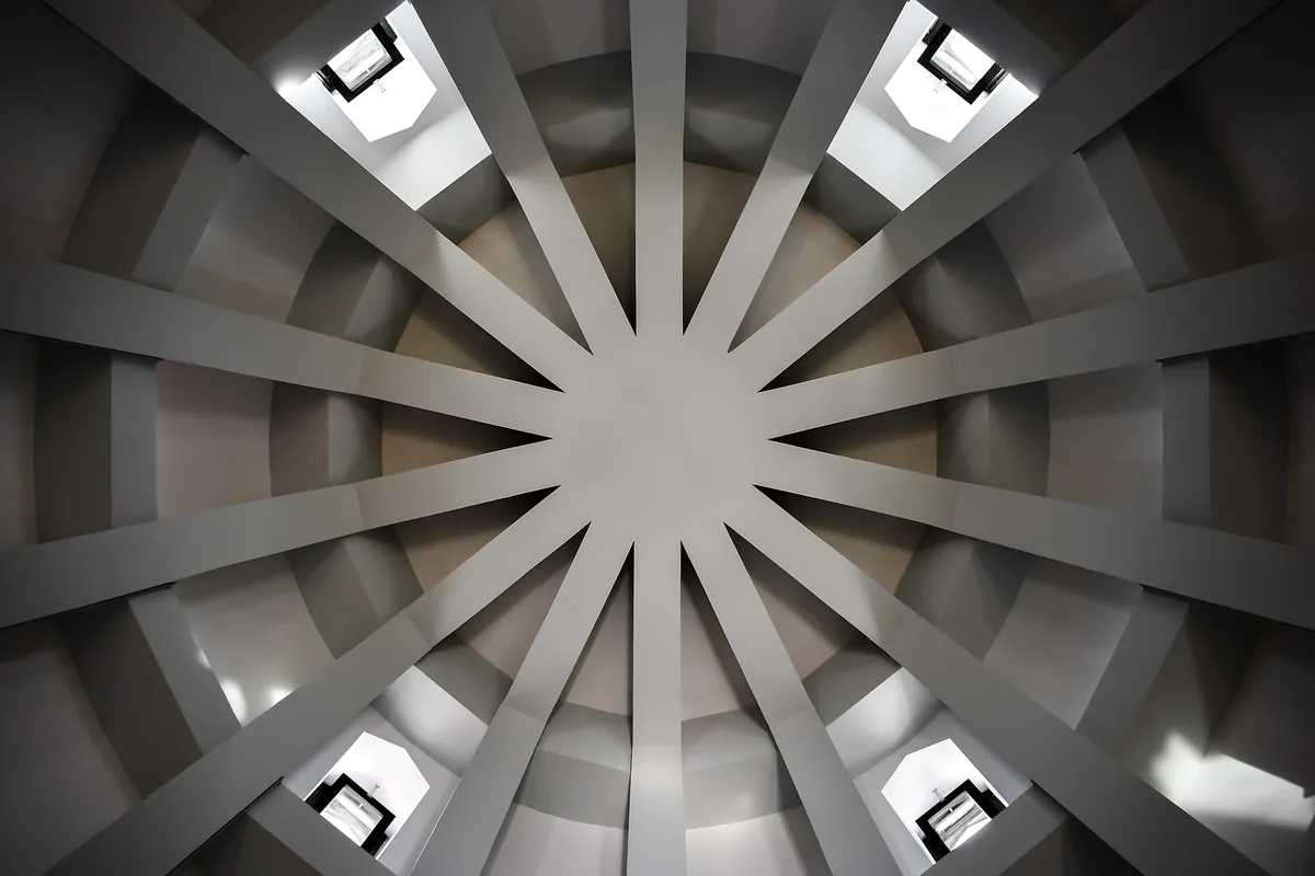 Looking up at the ribbed ceiling of the tower, with light coming through openings between the ribs.